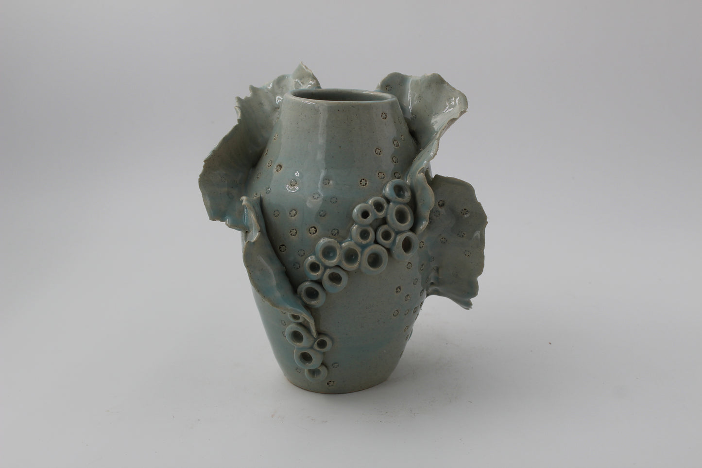 Ceramic vase with textured surface on a plain background