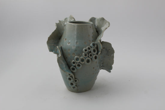 Ceramic vase with textured surface on a plain background